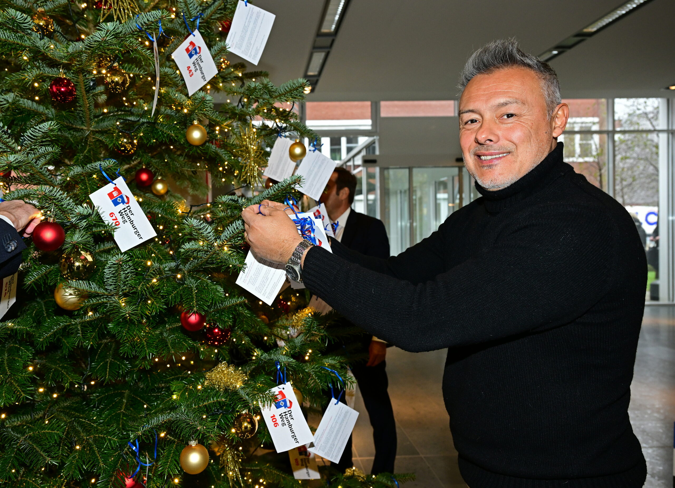 Rodolfo Esteban Cardoso schmückt einen Weihnachtsbaum.
