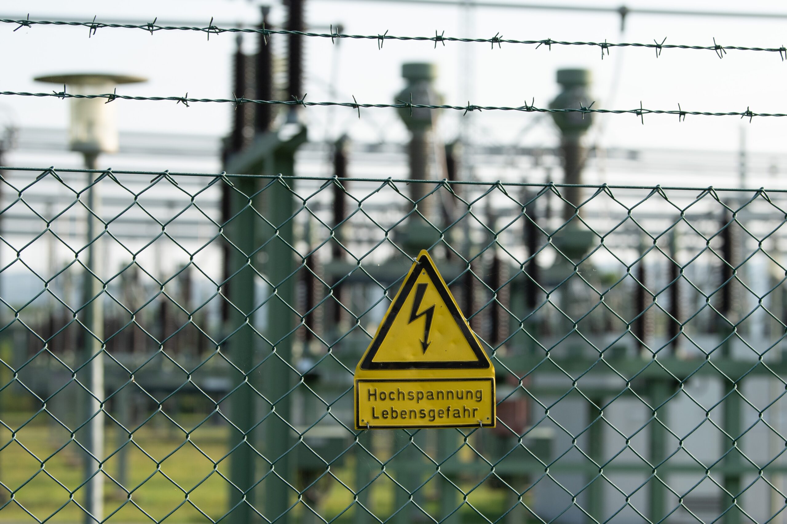 Ein Schild mit der Aufschrift „Hochspannung Lebensgefahr“ hängt an einem Zaun vor dem Gelände des Einspeise-Umspannwerks