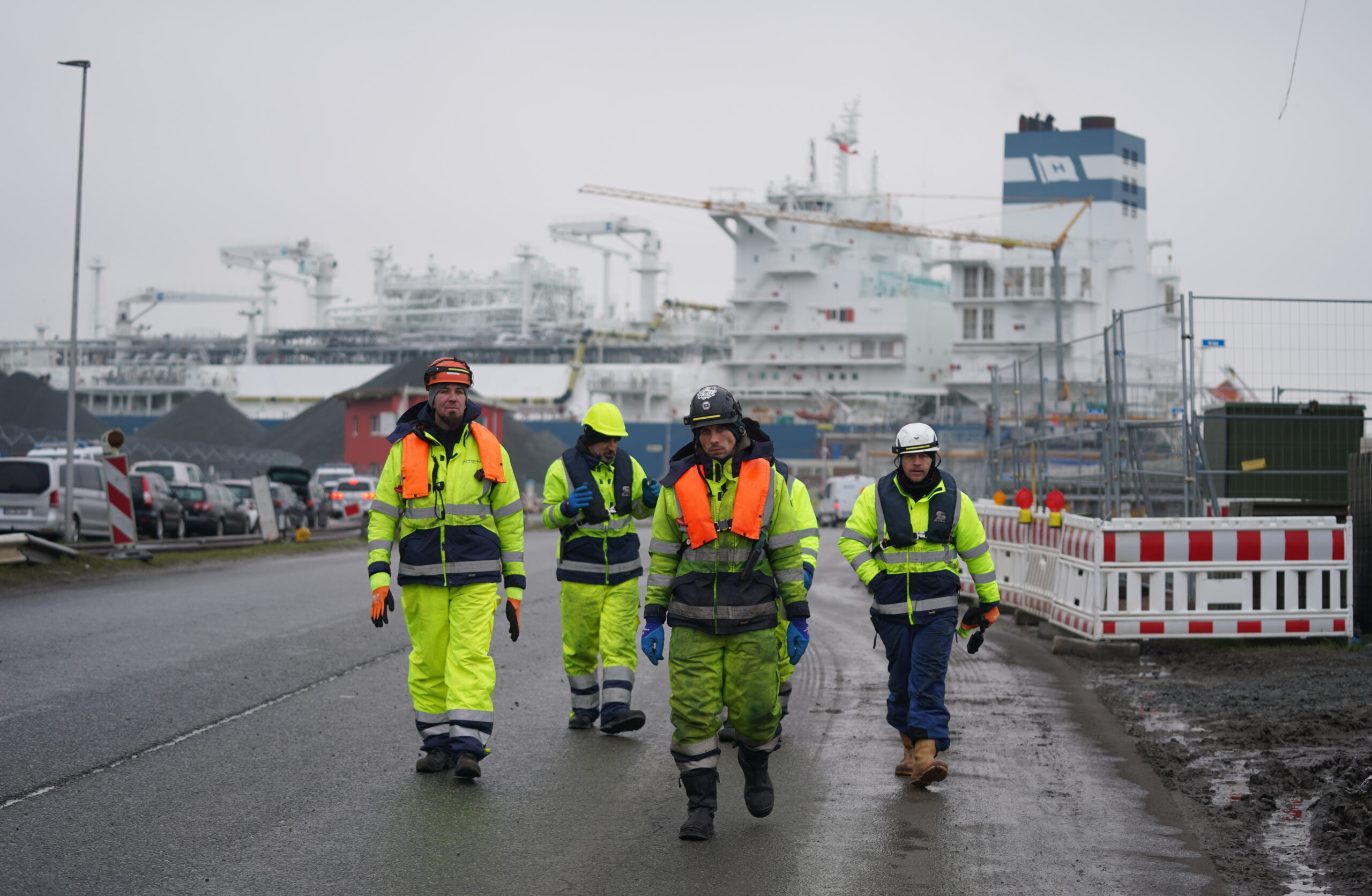Arbeiter vor dem schwimmenden LNG-Terminal „Höegh Gannet”, das im Industriehafen Brunsbüttel angekommen ist.