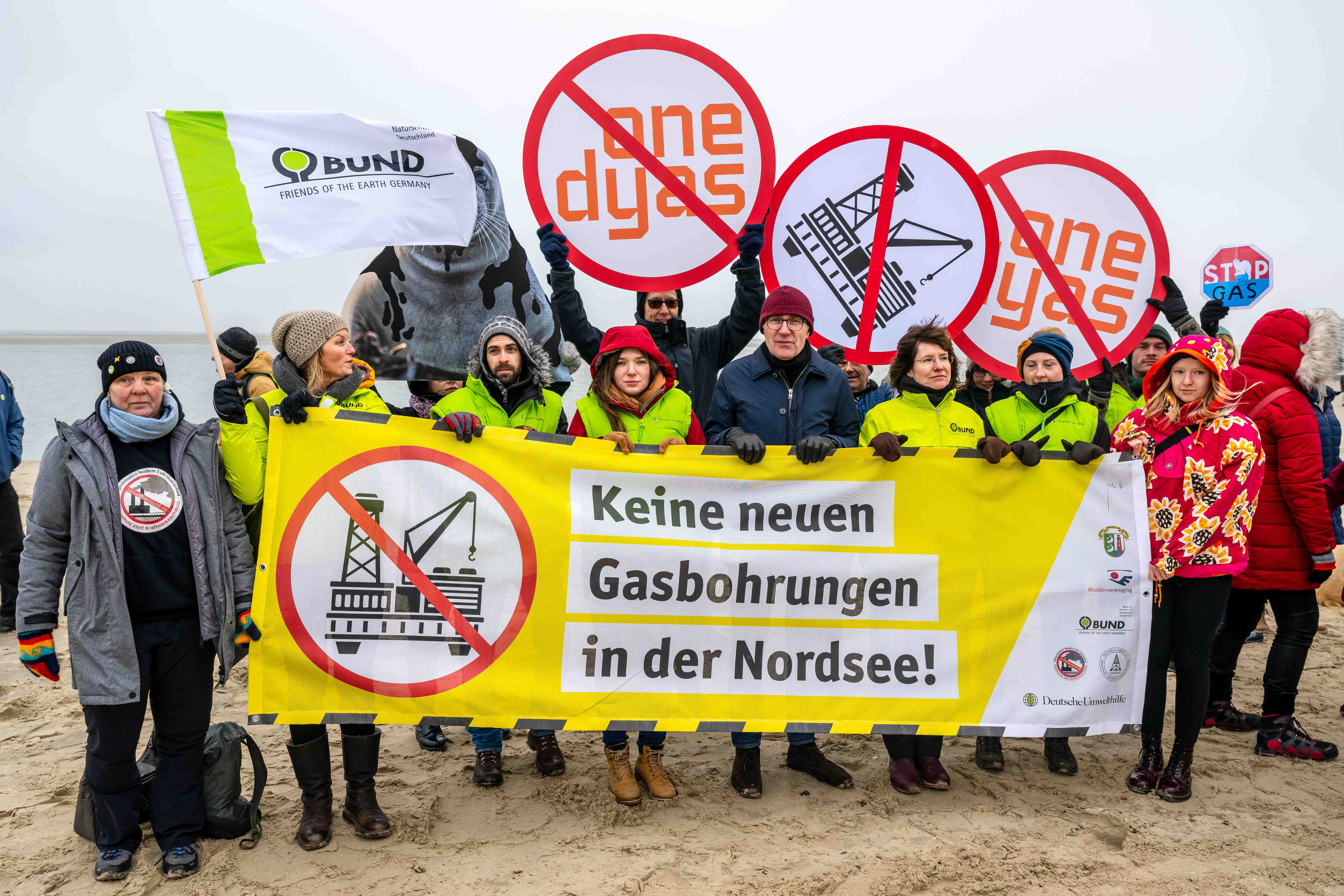 Umweltschützer und Insulaner demonstrieren am Weststrand mit Bannern und Plakaten gegen die geplante Erdgasförderung.