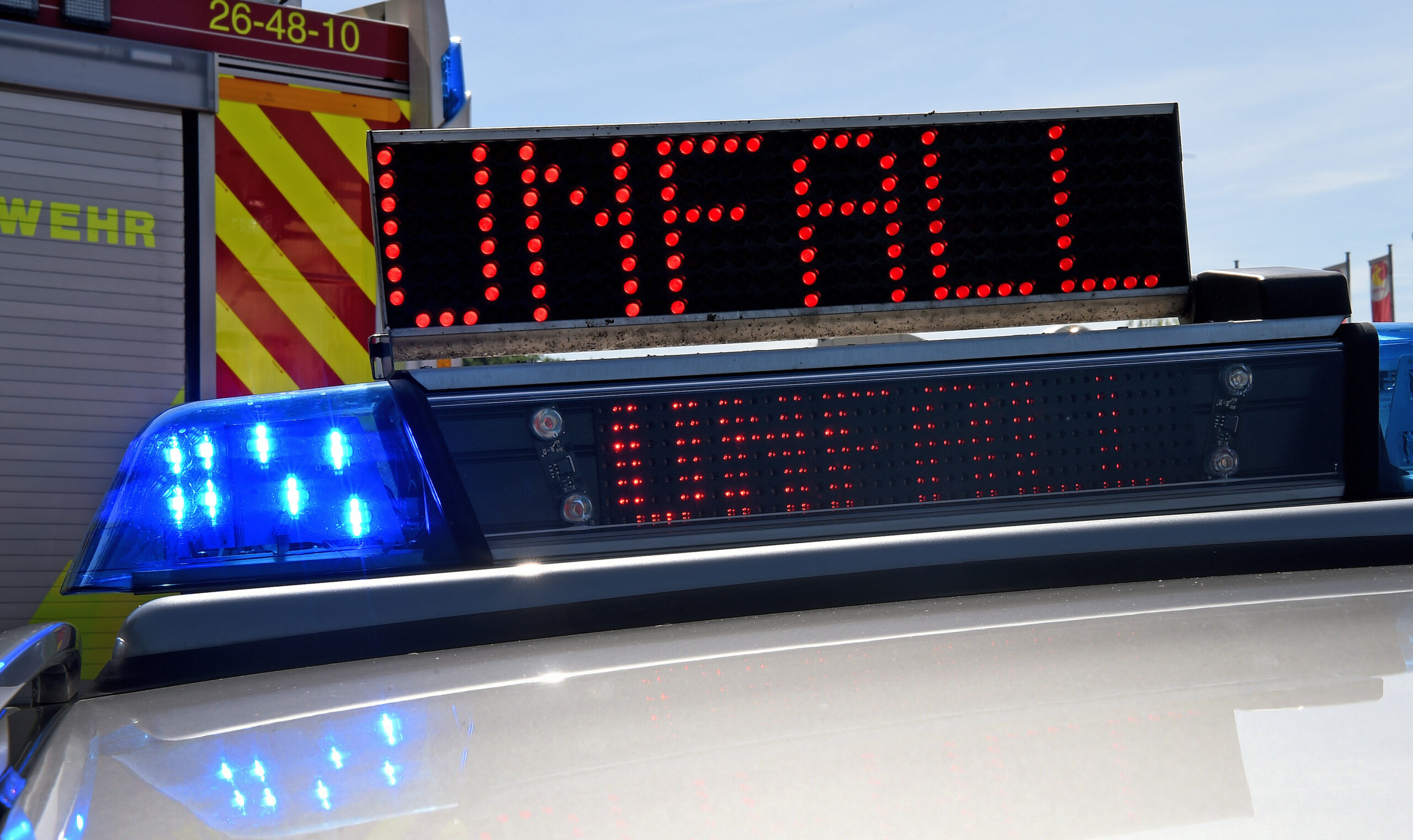 Polizeifahrzeug mit Blaulicht und LED-Laufschrift "Unfall"
