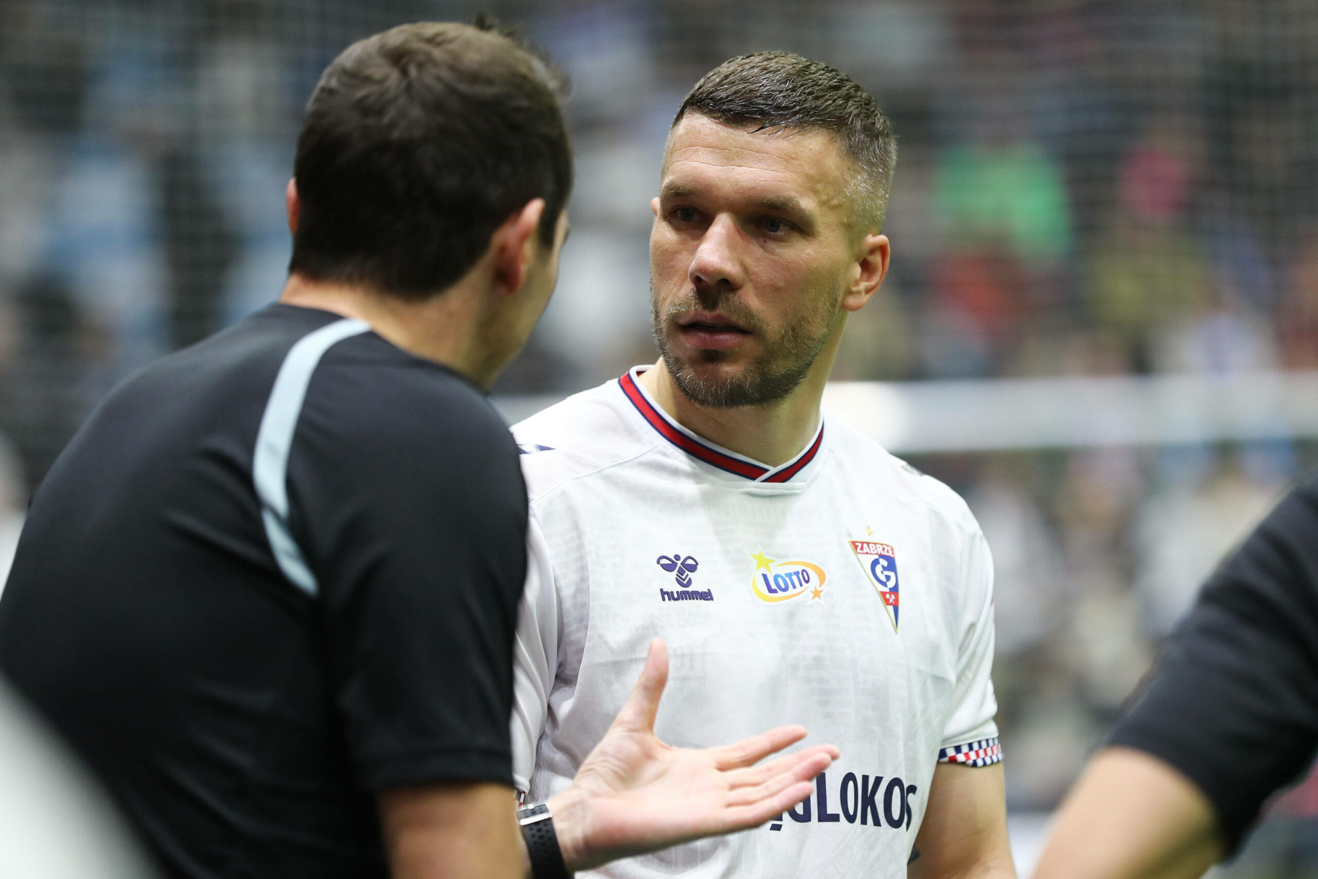 Lukas Podolski diskutiert mit dem Schiedsrichter.