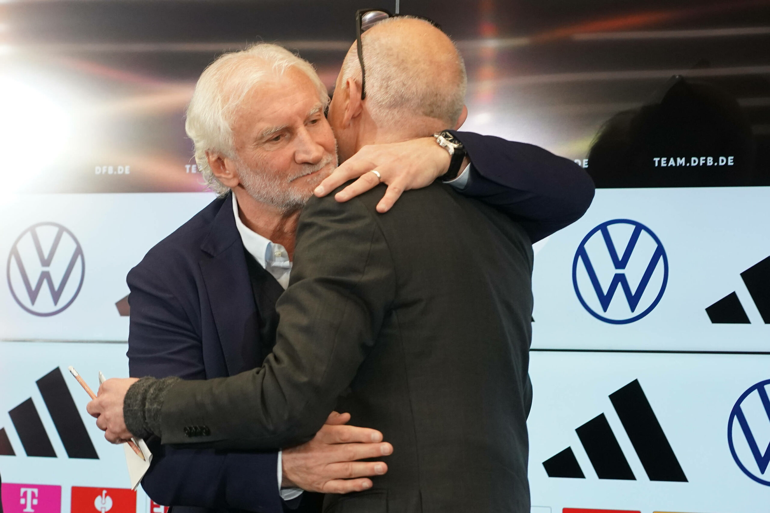 Rudi Völler umarmt Bernd Neuendorf bei einer Pressekonferenz