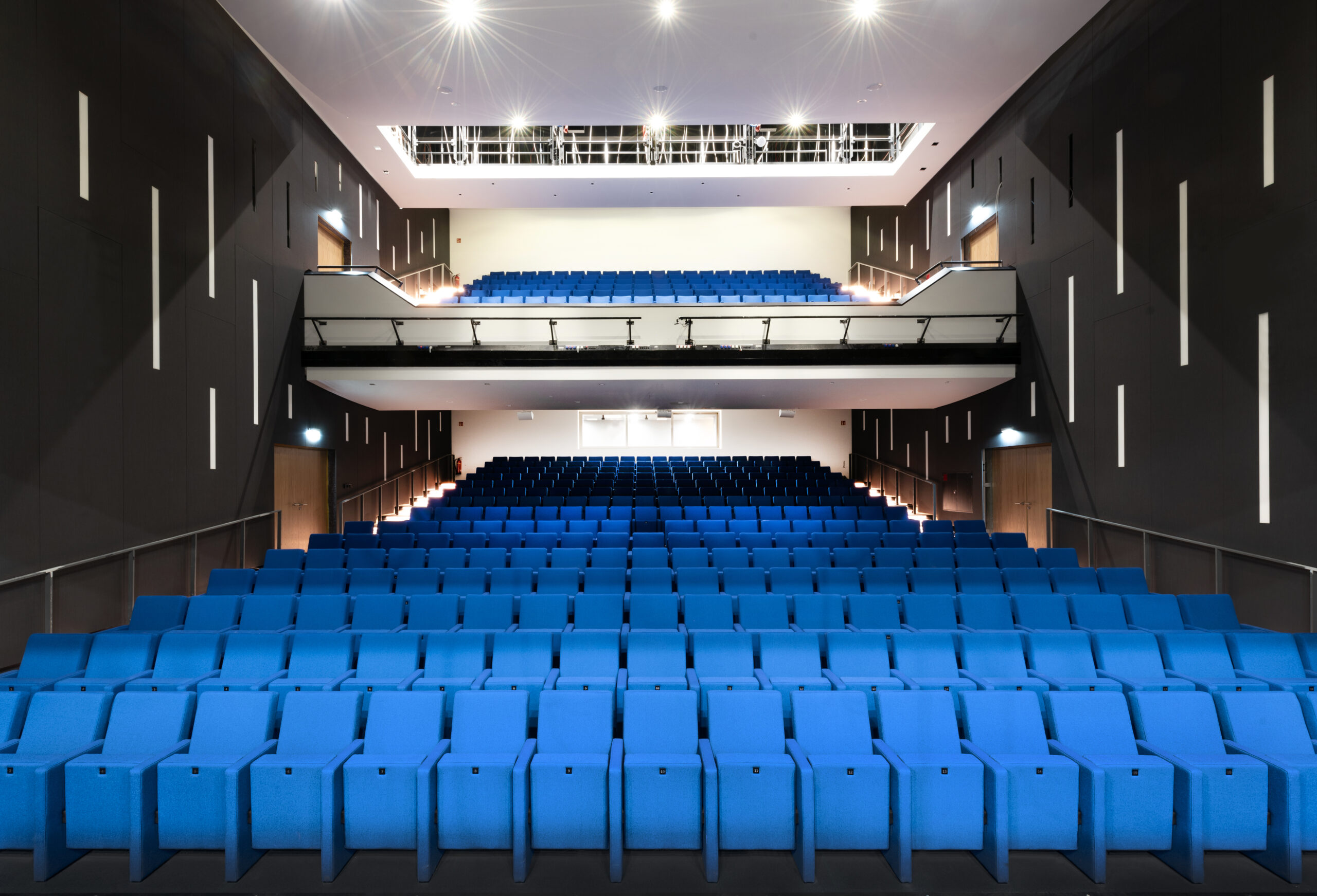 Theatersaal von der Bühne aus fotografiert. Die Sitze sind blau überzogen.