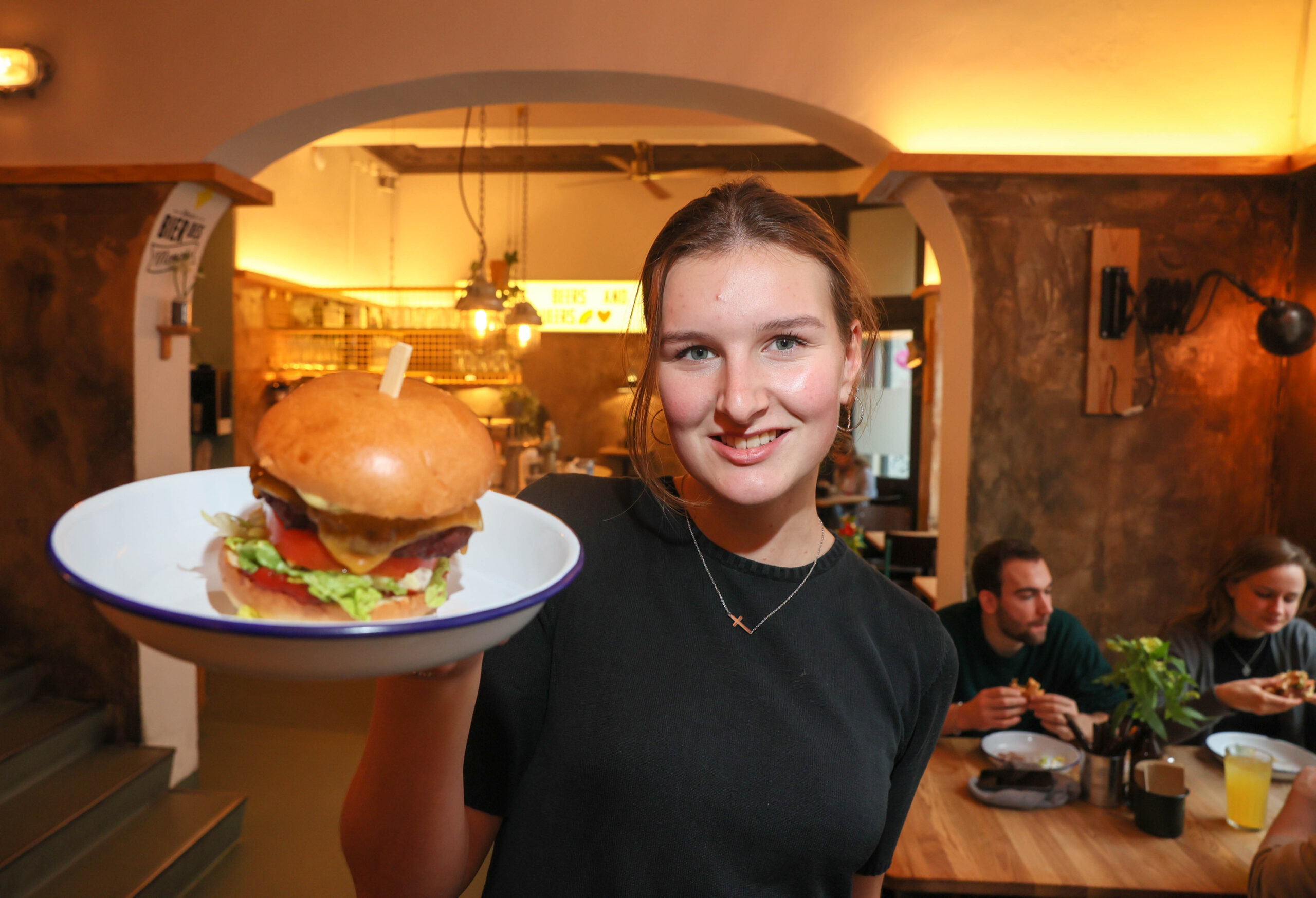 Charlotte (20) serviert einen vegetarischen Burger bei „Otto‘s Burger“