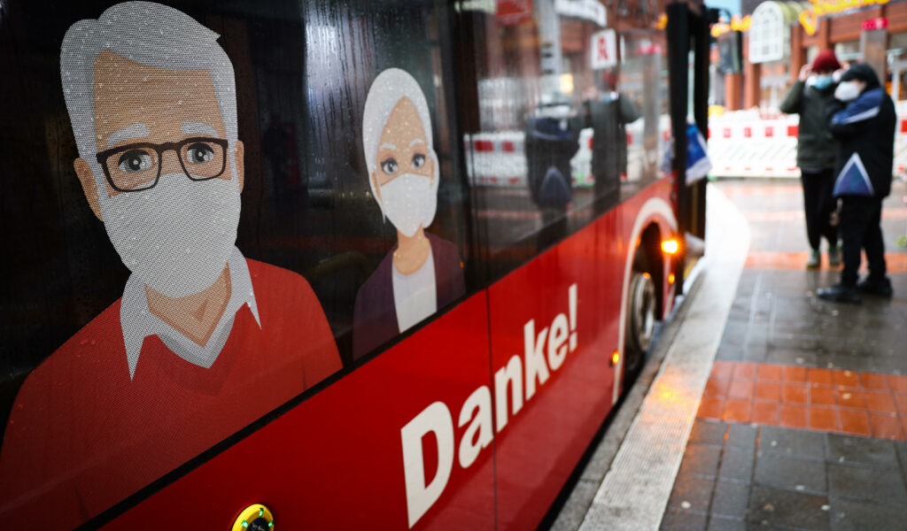 Ein Linienbus der Kieler Verkehrsgesellschaft KVG ist mit Hinweisen zum Tragen einer medizinischen Maske beklebt.
