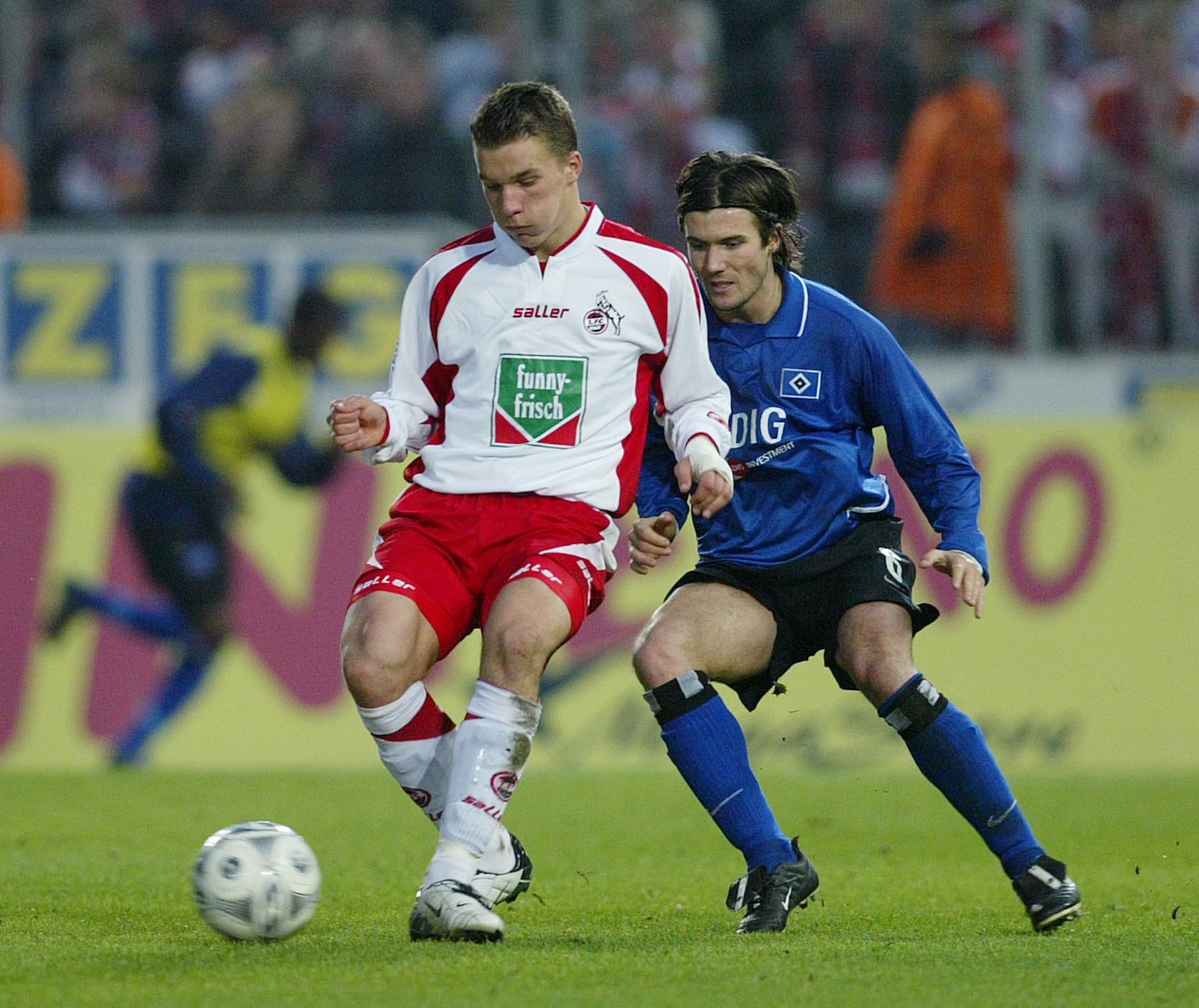 2003 feierte Podolski sein Debüt in der Bundesliga gegen den HSV (hier gegen Wicky/r.)